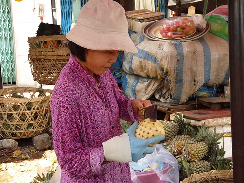 Stallholder preparing pineapples at the local market